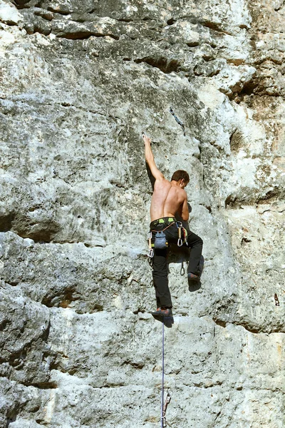 Rock climber climbing up a cliff — Stock Photo, Image