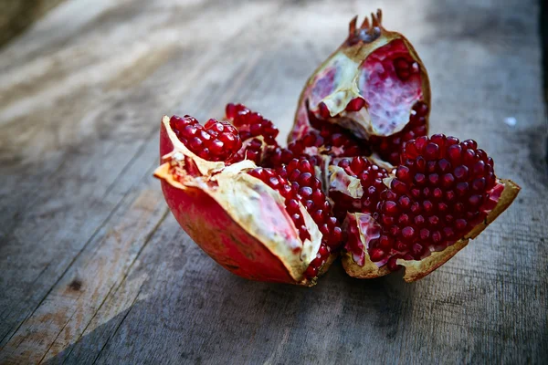 Pomegranates on a dark wooden background — Stock Photo, Image