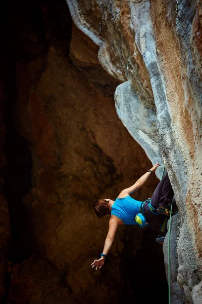 Rock climber climbing up a cliff — Stock Photo, Image