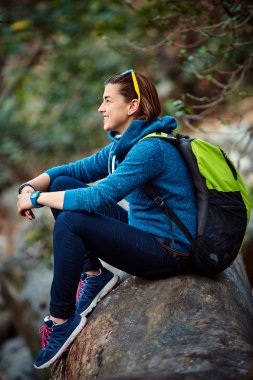 Sırt çantası ile orman dışında ayakta gülümseyen kadın uzun yürüyüşe çıkan kimse