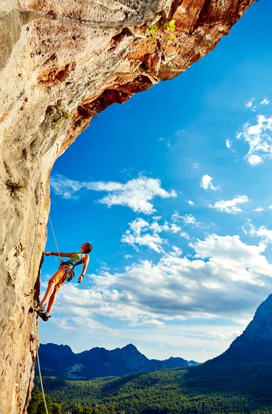 Rock climber climbing up a cliff — Stock Photo, Image