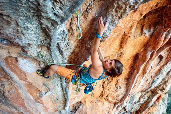 Rock climber climbing up a cliff — Stock Photo, Image