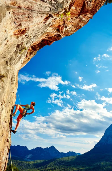 Rock climber climbing up a cliff Stock Image