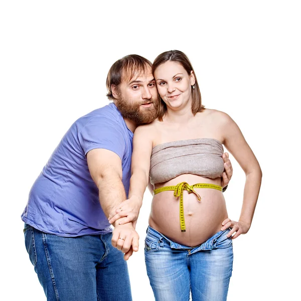 Jeune famille attendant bébé sur fond blanc — Photo