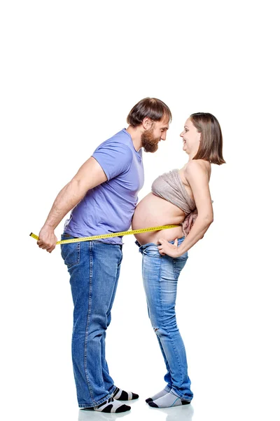 Jeune famille attendant bébé sur fond blanc — Photo