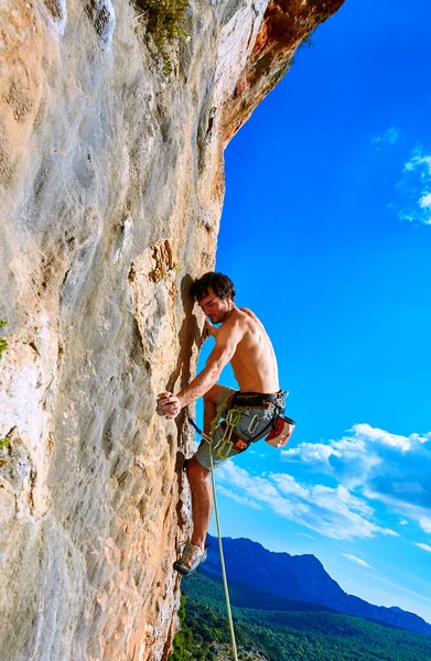 Rock climber climbing up a cliff — Stock Photo, Image