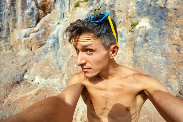 Jonge man op de achtergrond van de rots — Stockfoto
