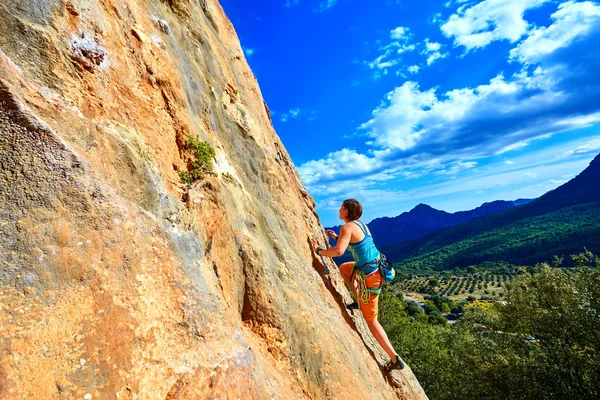 Rock climber climbing up a cliff — Stock Photo, Image