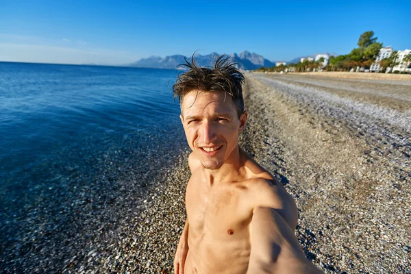 Gelukkig jonge man op het strand — Stockfoto