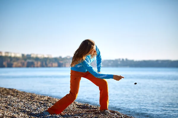 Lány játszik a tengerre tengerparton — Stock Fotó