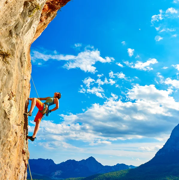 Kletterer klettert eine Klippe hinauf lizenzfreie Stockfotos