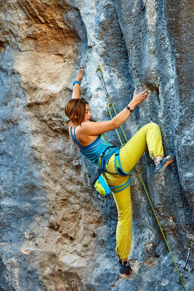 Rock climber climbing up a cliff — Stock Photo, Image