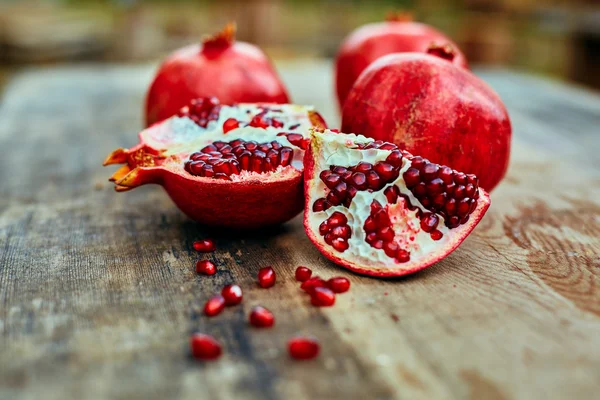 Pomegranates on a dark wooden background — Stock Photo, Image