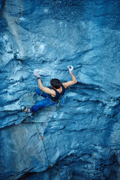 Rock climber climbing up a cliff — Stock Photo, Image