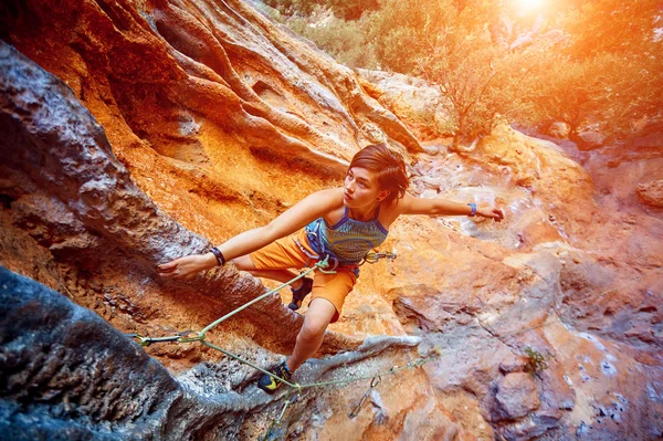 Rock climber climbing up a cliff — Stock Photo, Image