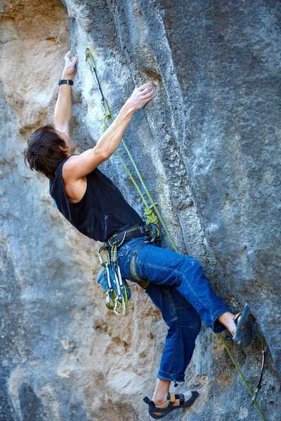 Rock climber climbing up a cliff — Stock Photo, Image