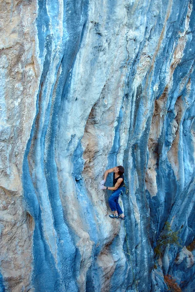 Rock climber climbing up a cliff — Stock Photo, Image