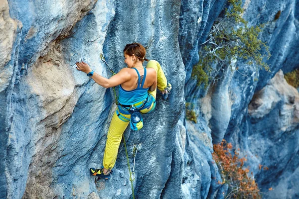 Rock climber climbing up a cliff — Stock Photo, Image