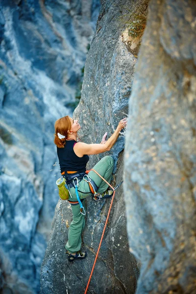 Rock climber climbing up a cliff — Stock Photo, Image