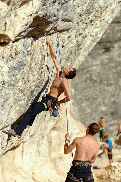 Rock climber climbing up a cliff — Stock Photo, Image