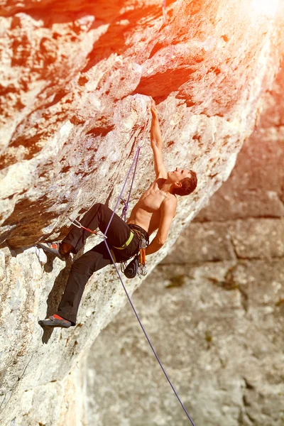 Rock climber climbing up a cliff — Stock Photo, Image