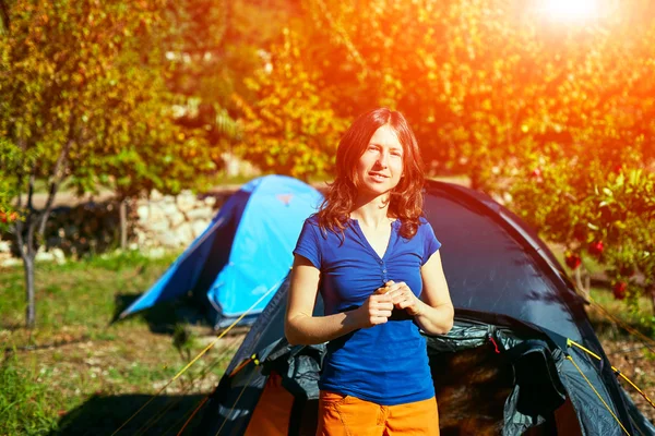 Nuori nainen lähellä telttaa — kuvapankkivalokuva