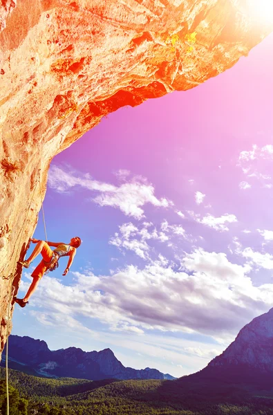 Rock climber climbing up a cliff — Stock Photo, Image