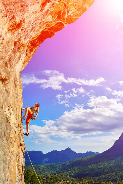 Rock climber climbing up a cliff — Stock Photo, Image