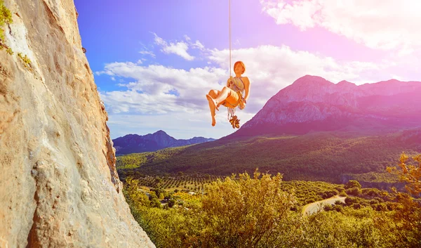 Rock climber climbing up a cliff — Stock Photo, Image