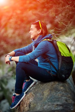 Sırt çantası ile orman dışında ayakta gülümseyen kadın uzun yürüyüşe çıkan kimse