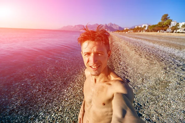 Gelukkig jonge man op het strand — Stockfoto
