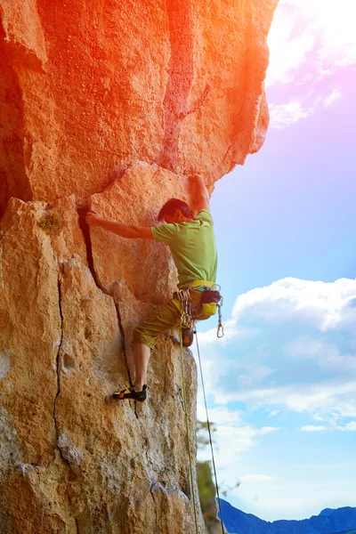 Rock climber climbing up a cliff — Stock Photo, Image