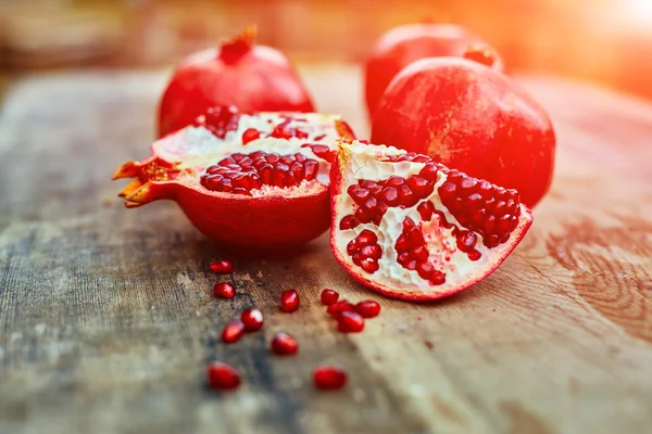 Pomegranates on a dark wooden background — Stock Photo, Image