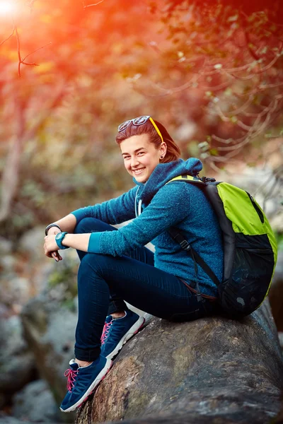 Sırt çantası ile orman dışında ayakta gülümseyen kadın uzun yürüyüşe çıkan kimse