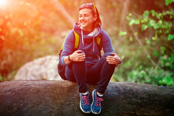 Mujer excursionista sonriendo de pie afuera en el bosque con mochila —  Fotos de Stock