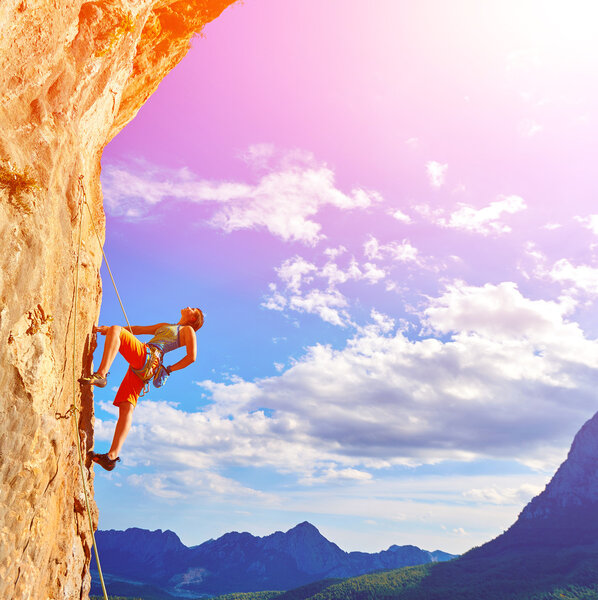 Rock climber climbing up a cliff