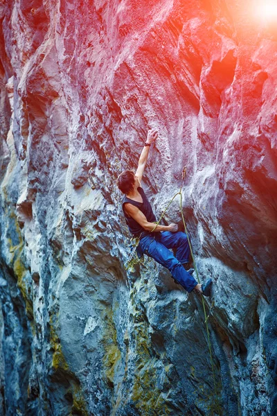 Rock climber climbing up a cliff — Stock Photo, Image