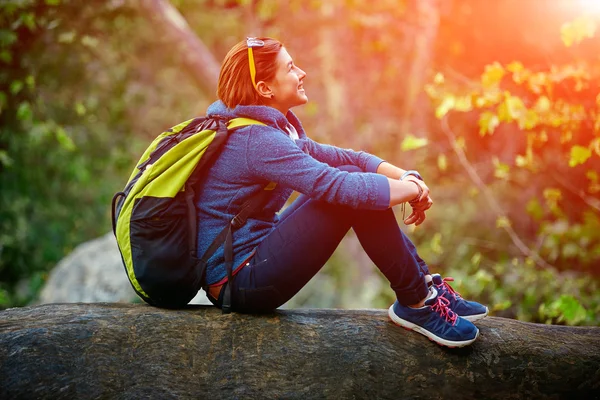 Mujer excursionista sonriendo de pie afuera en el bosque con mochila — Foto de Stock