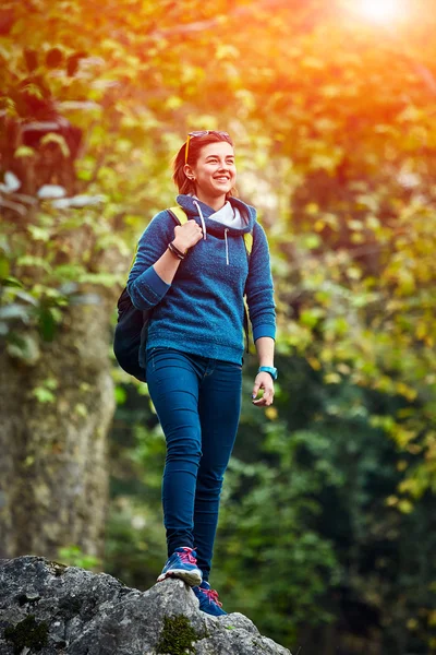 Wanderin steht lächelnd mit Rucksack im Wald — Stockfoto