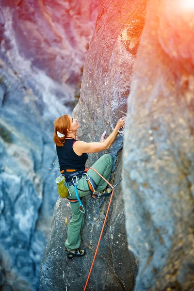 Rock climber climbing up a cliff — Stock Photo, Image