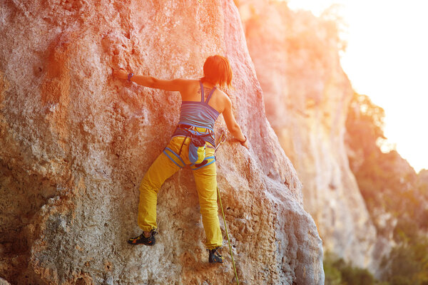 Rock climber climbing up a cliff