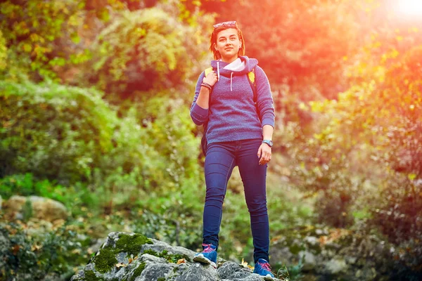 Mujer excursionista sonriendo de pie afuera en el bosque con mochila —  Fotos de Stock