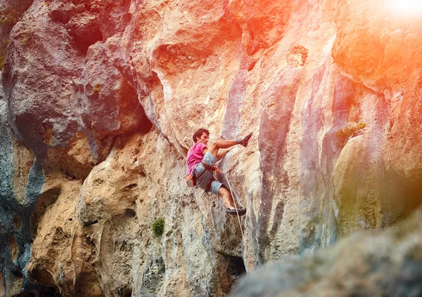 Rock climber climbing up a cliff — Stock Photo, Image