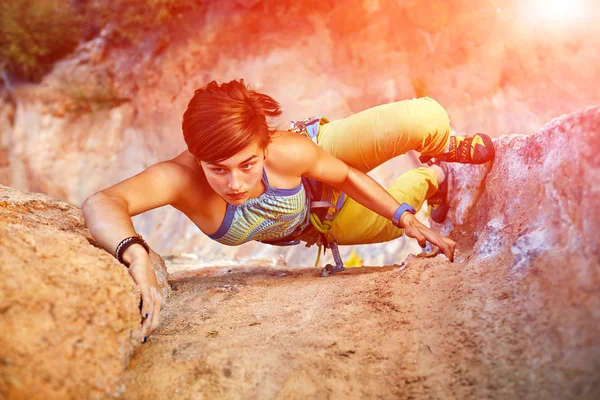 Rock climber climbing up a cliff Stock Picture