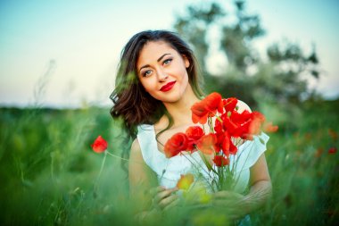 Çiçekli haşhaş bir alanda güzel kadın