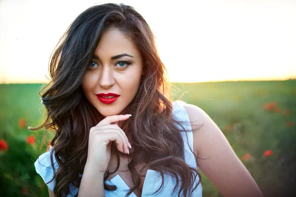 Hermosa mujer en un campo de amapola con flores —  Fotos de Stock