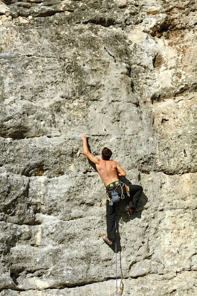 Rock climber climbing up a cliff — Stock Photo, Image