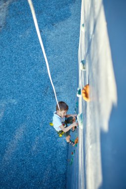 Little boy in  rock climbing gym