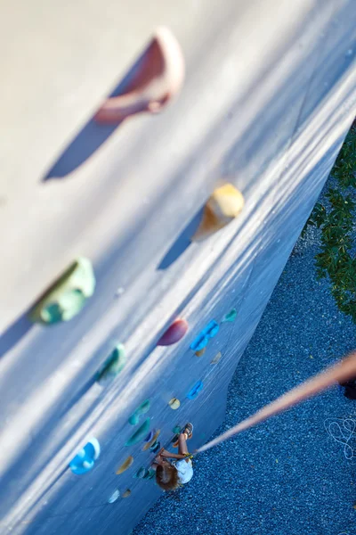 Pieni tyttö kalliokiipeilyä kuntosalilla — kuvapankkivalokuva