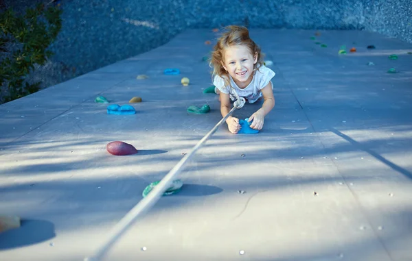 Little girl in  rock climbing gym